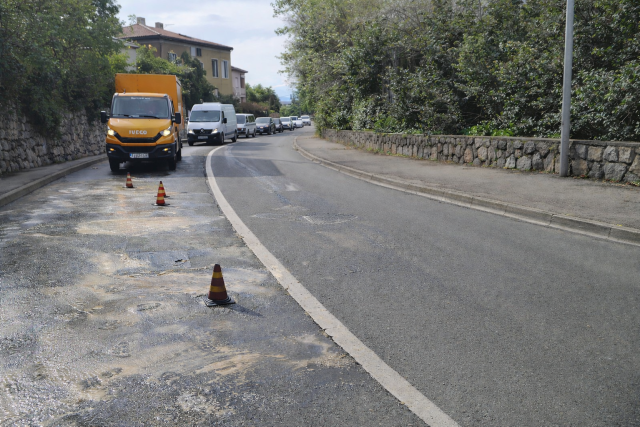Zametska ulica u Rijeci s tragovima izlivenog ulja na kolniku, prometni čunjevi označavaju sklisku dionicu dok se vozila kreću usporeno.