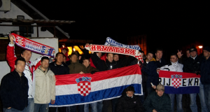 Skupina navijača drži hrvatske zastave i obilježja Armade, uključujući zastavu s natpisom Rijeka i šal Hrvatske.