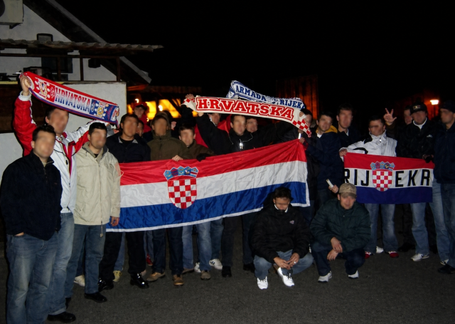 Skupina navijača drži hrvatske zastave i obilježja Armade, uključujući zastavu s natpisom Rijeka i šal Hrvatske.