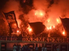 Navijači na stadionu s bakljama i dimom stvaraju vatrenu atmosferu tijekom nogometne utakmice između Rijeke i Hajduka