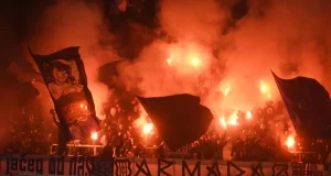 Navijači na stadionu s bakljama i dimom stvaraju vatrenu atmosferu tijekom nogometne utakmice između Rijeke i Hajduka