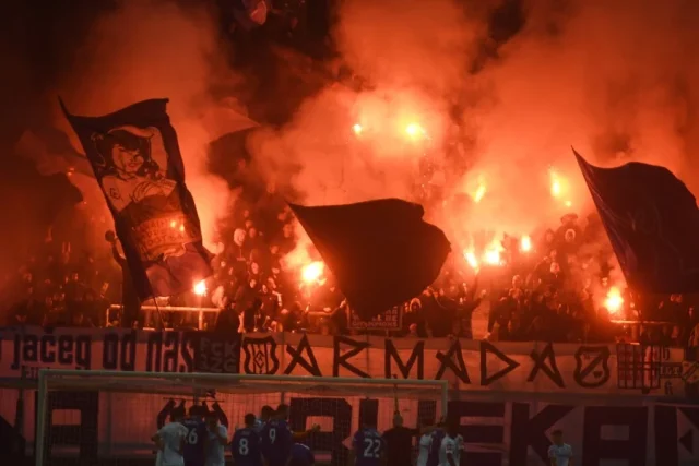 Navijači na stadionu s bakljama i dimom stvaraju vatrenu atmosferu tijekom nogometne utakmice između Rijeke i Hajduka