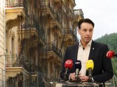 Gradonačelnik Fernando Kirigin govori na konferenciji za medije, u pozadini zgrada u Opatiji s postavljenim skelama i zaštitnim mrežama.