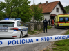 Policijski automobil i vozilo hitne pomoći ispred kuće u selu, uz policijsku traku tijekom očevida
