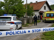 Policijski automobil i vozilo hitne pomoći ispred kuće u selu, uz policijsku traku tijekom očevida