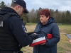 Ilustracija policijske kontrole žene u Latviji nakon viralne snimke povezane s torbicom u bojama koje podsjećaju na rusku zastavu.